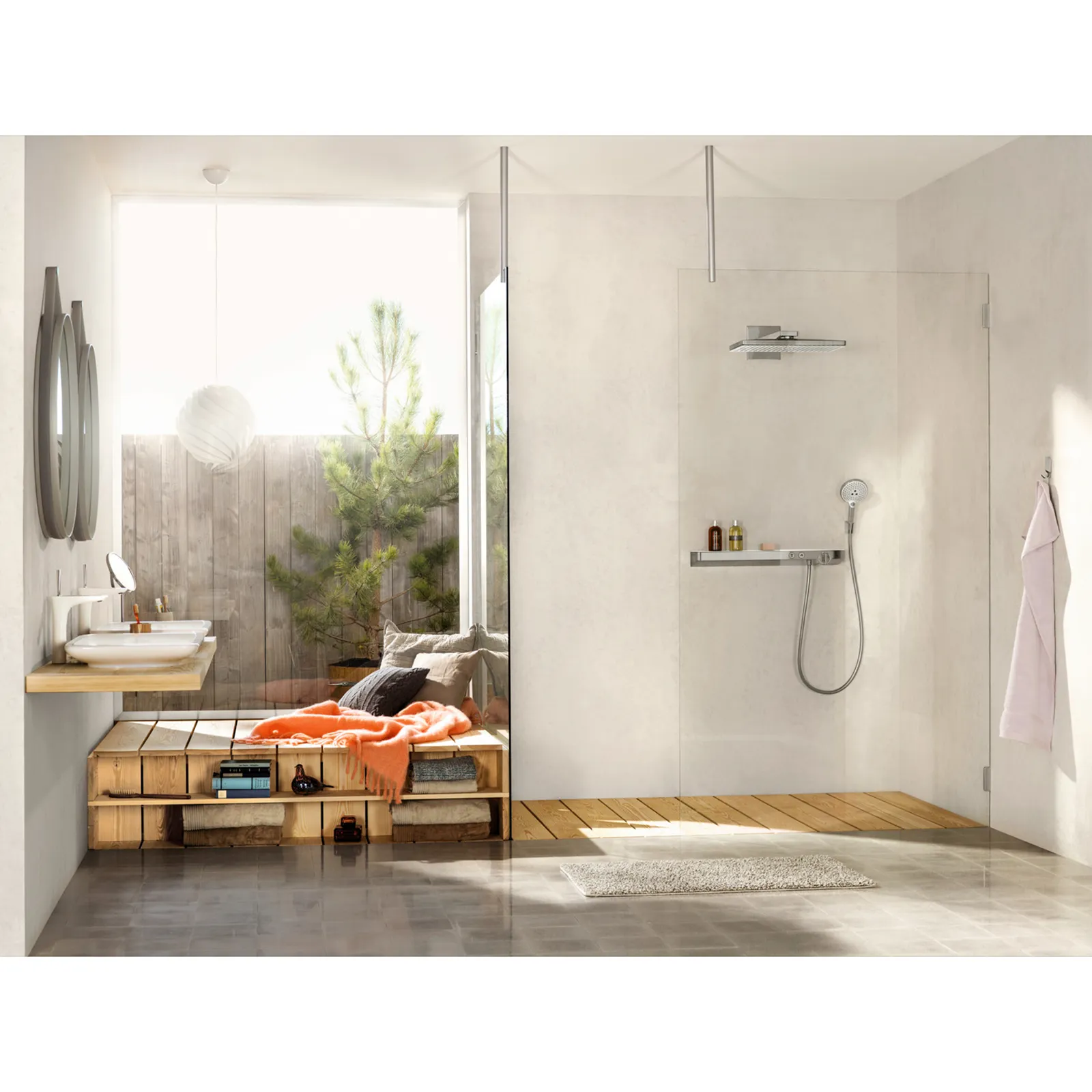 Ein modernes Badezimmer mit großen Fenstern bietet eine Dusche mit Glastrennwand und Regenbrause. Am Waschbecken aus Holz sind zwei runde Spiegel. Eine gemütliche Sitzecke ist mit Kissen und einer Decke ausgestattet.