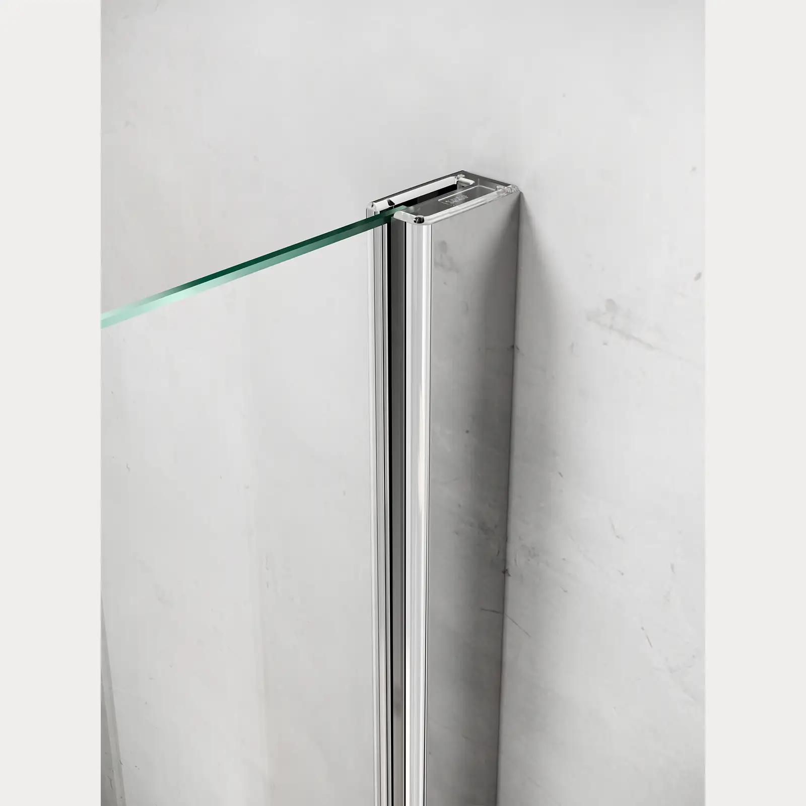 Ein quadratischer, polierter Aluminium-Rahmen hält eine transparente Glastür. Der Rahmen ist an einer glatten, hellen Wand befestigt, die modern und minimalistisch wirkt.