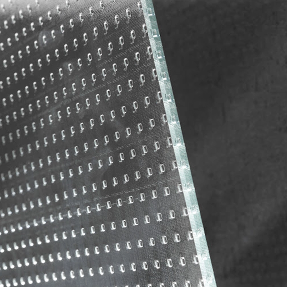 Ein transparentes Material mit einem strukturierten Muster von kleinen, runden Vertiefungen ist schräg präsentiert. Der Hintergrund ist dunkel und hebt die Textur des Materials hervor.